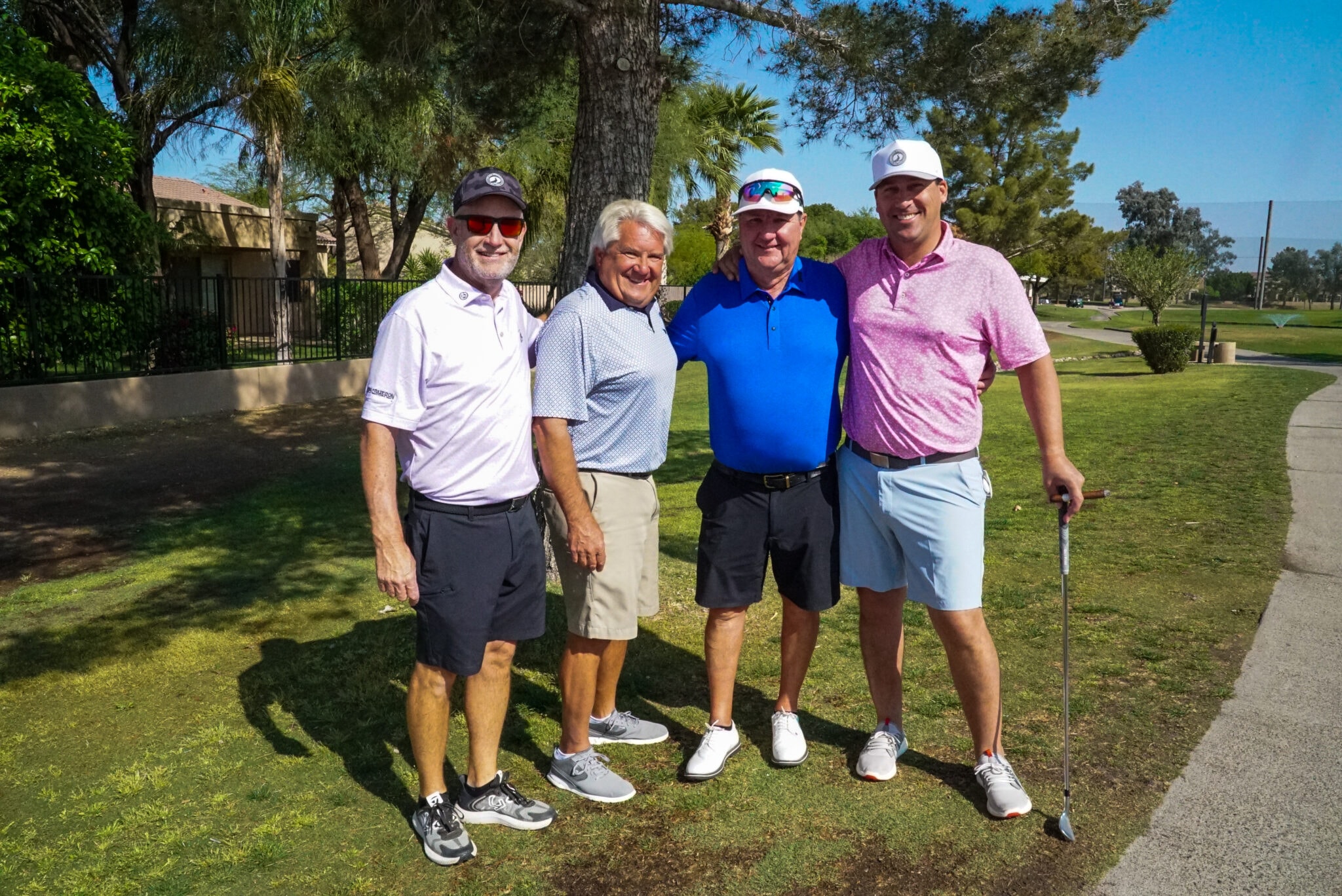 Four golfers posing together on the course at the BTG charity tournament