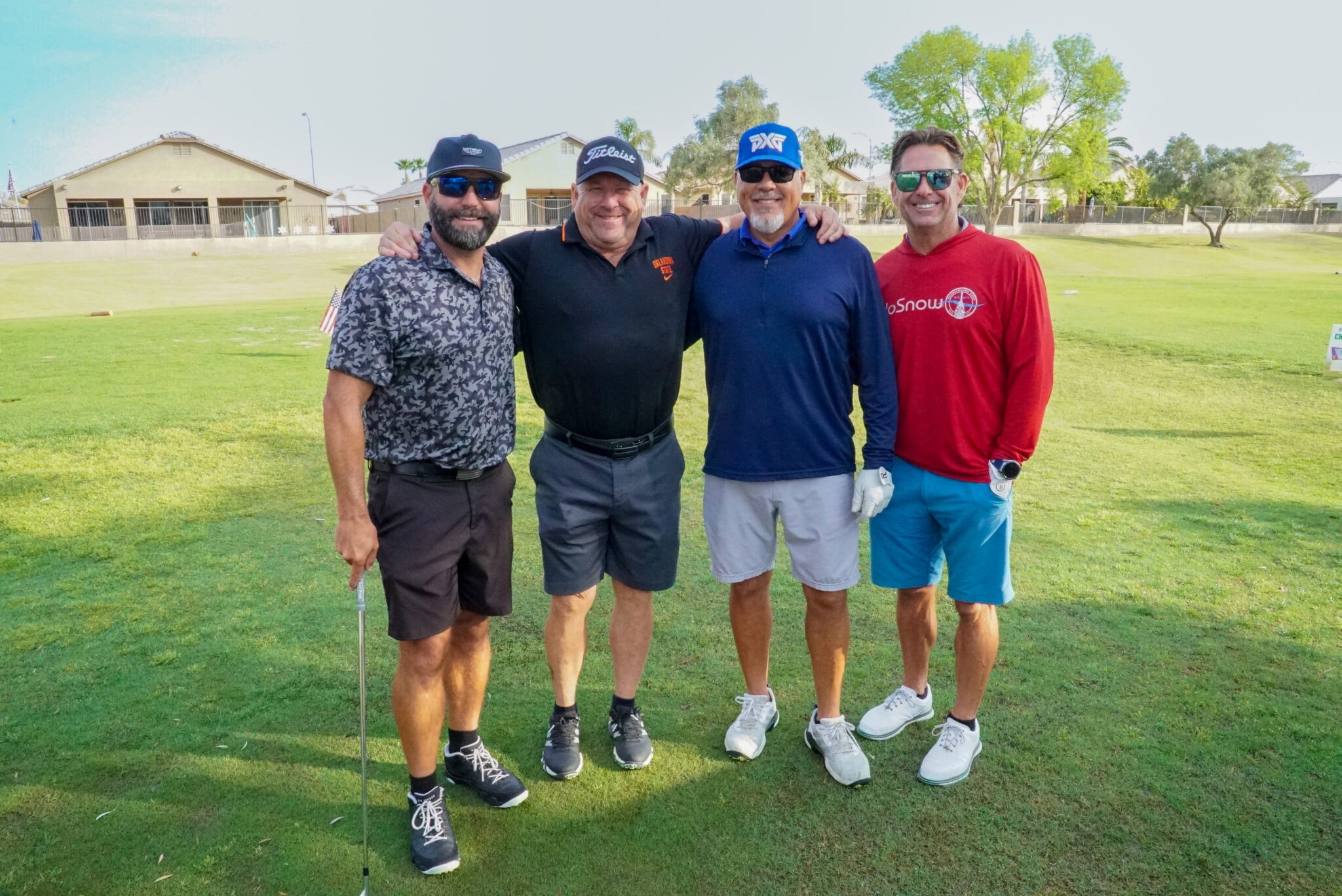 Four golfers posing together on the course