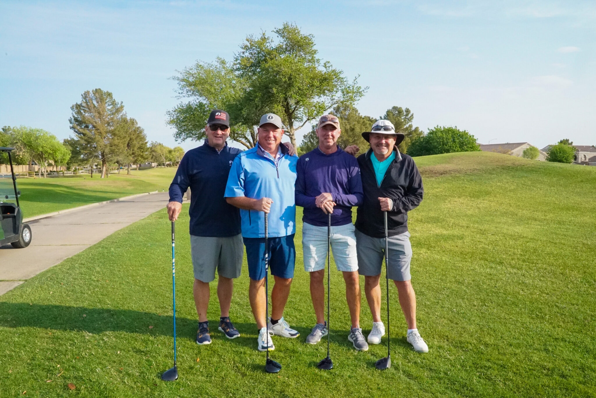 Four golfers with clubs on the fairway